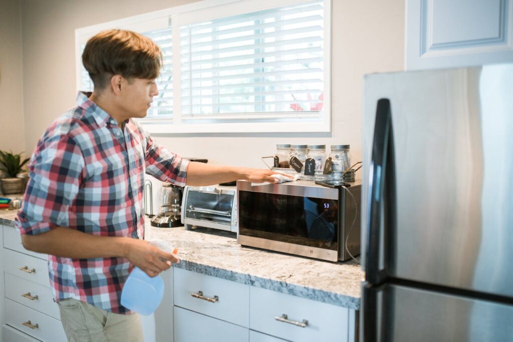 man-wiping-microwave
